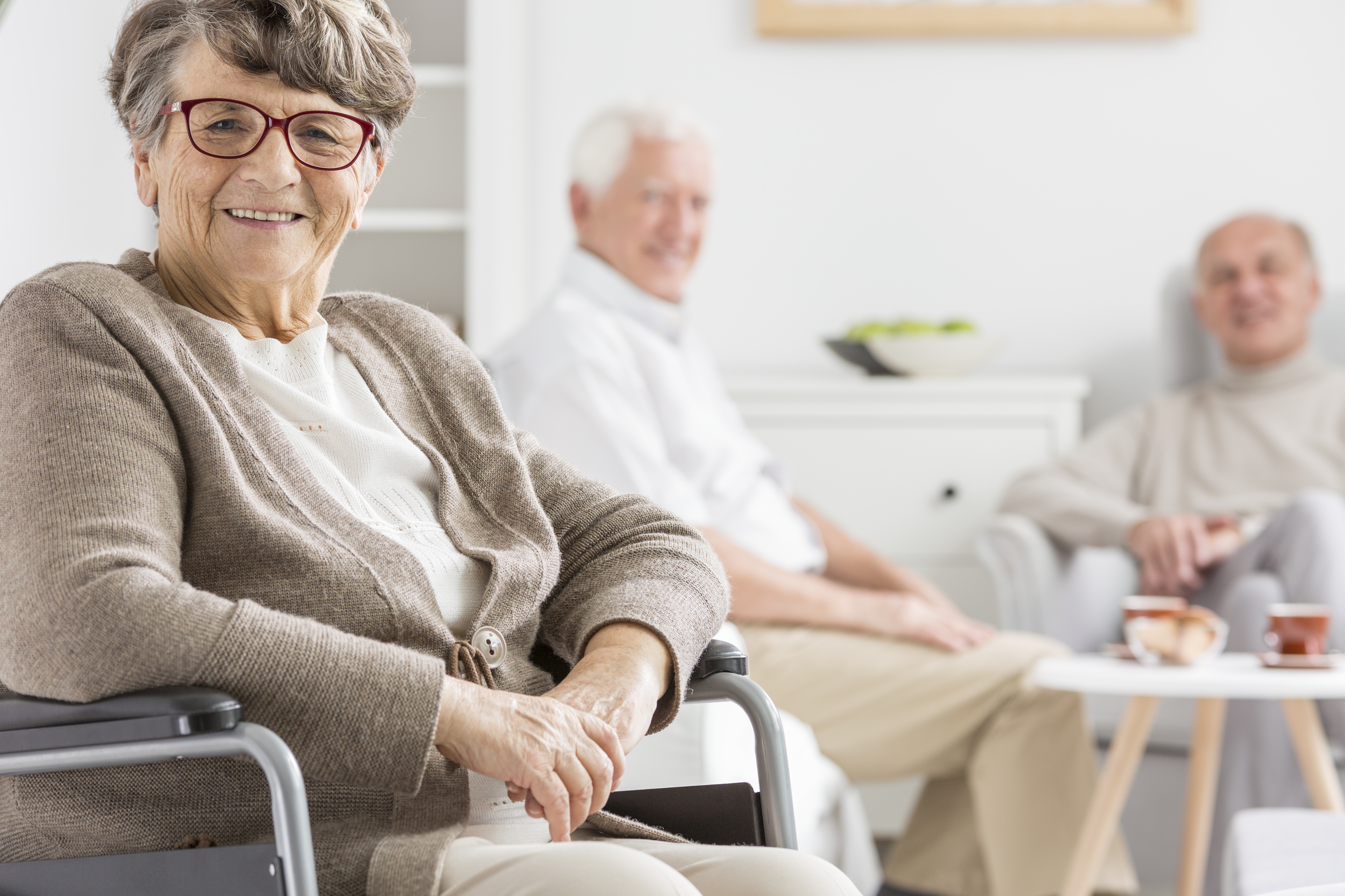 Smiling woman on a wheelchair in a retirement residence